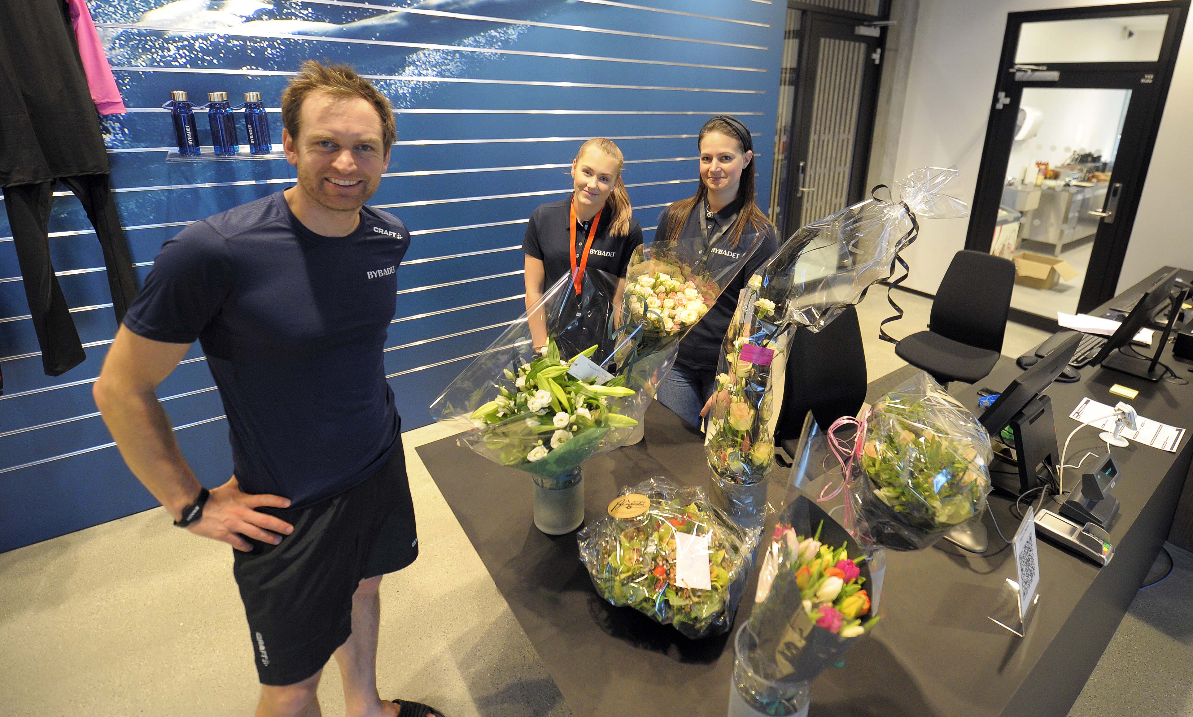 Daglig leder Lasse Hoel, Natalie Nilsen og Mary-Lou Meixner kunne i dag ta mot de første badegjestene til Bybadet. Blomtrene de har fått vitner om at de har vært etterlengtet.