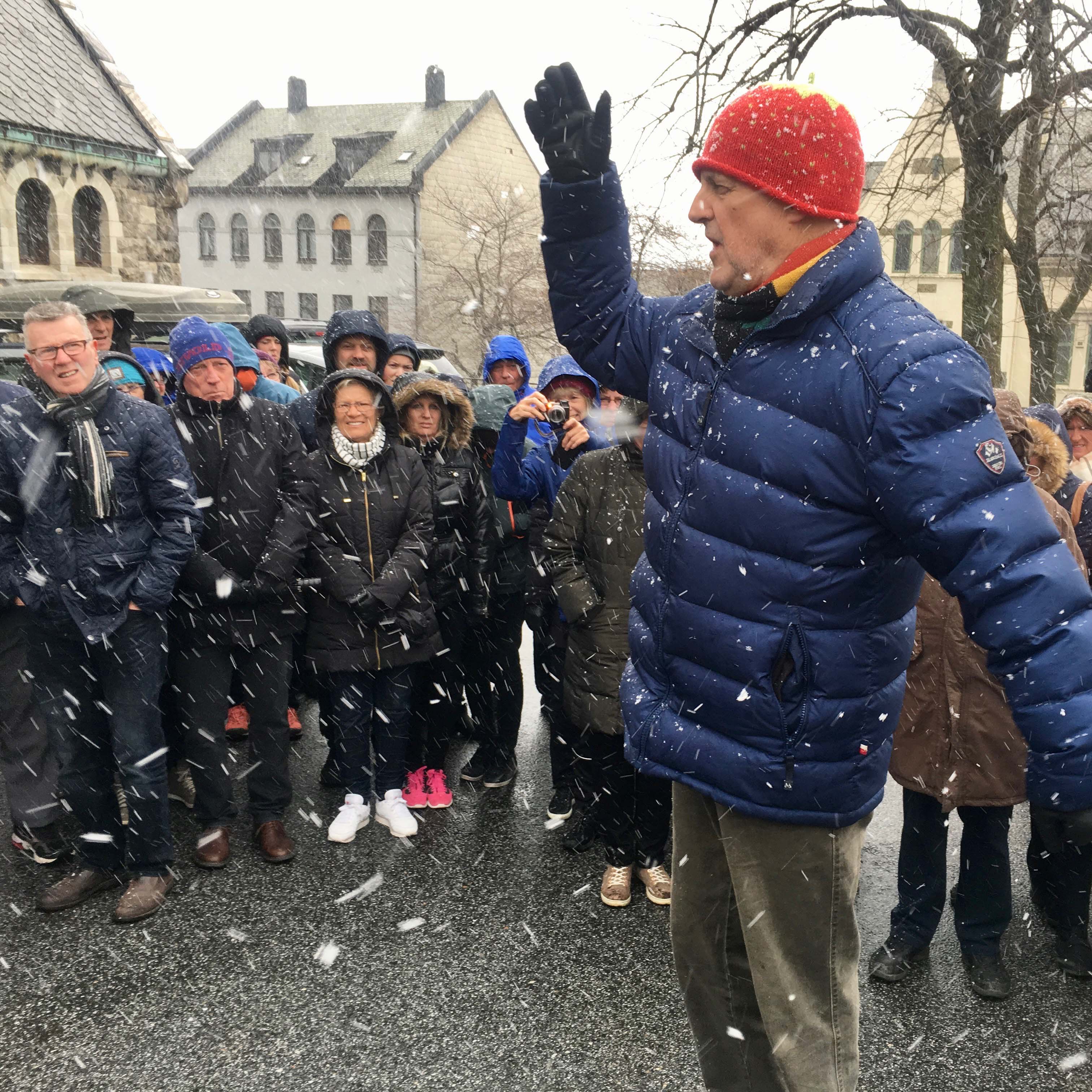 Harald Grytten i kjent stil. Han lar seg ikke stoppe av noe, minst av alt vind eller vær der han formidler byhistorie med et brennende engasjement!