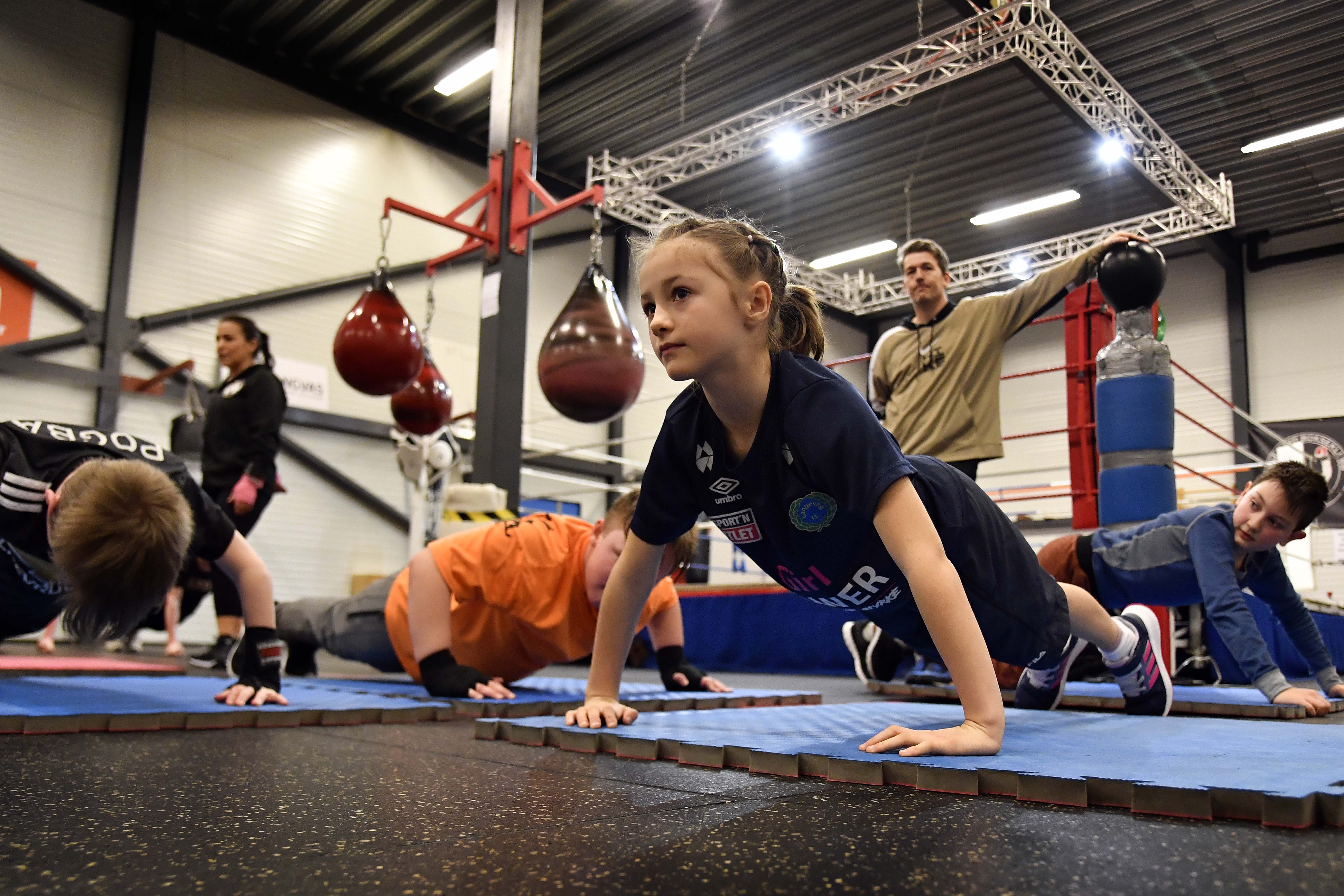 Zuzanna (7) utfører armhevinger under kyndig overblikk fra Richard Tomren og Yaneth Skjønberg i bakgrunnen.