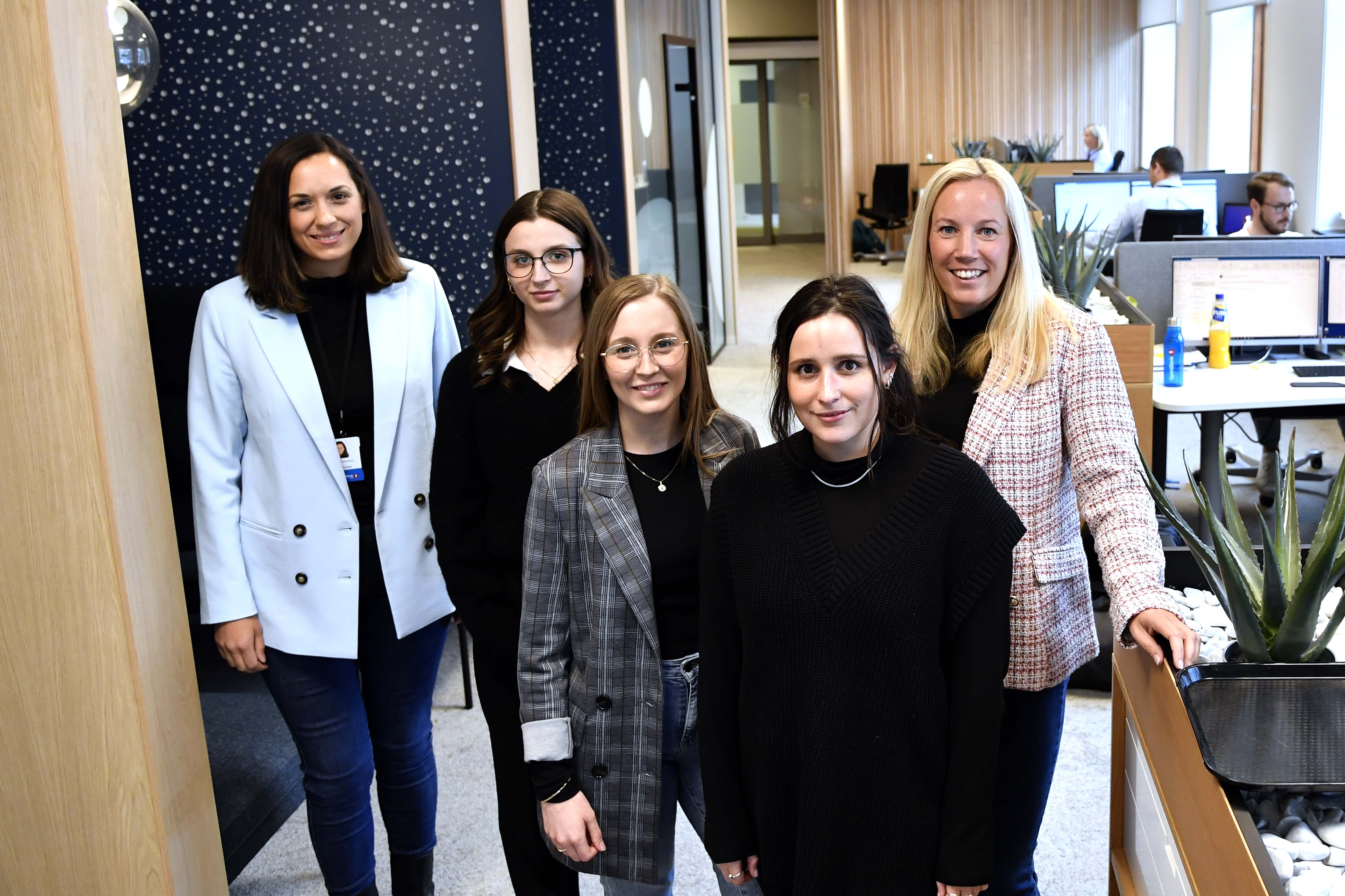 De tre studentene har funnet seg godt til rette i Sparebank1 SMN sine lokaler på St. Olavs plass. Her sammen med Tillique Rørstad Røyset (t.h) som er finansrådgiver og fagansvarlig for opplæring i banken og som selv har studert i England. Regionbanksjef for Sparebank1 SMN Marita Løvik Stadsnes (t.h). Begge er strålende fornøyd med jobben de tre gjør i banken.