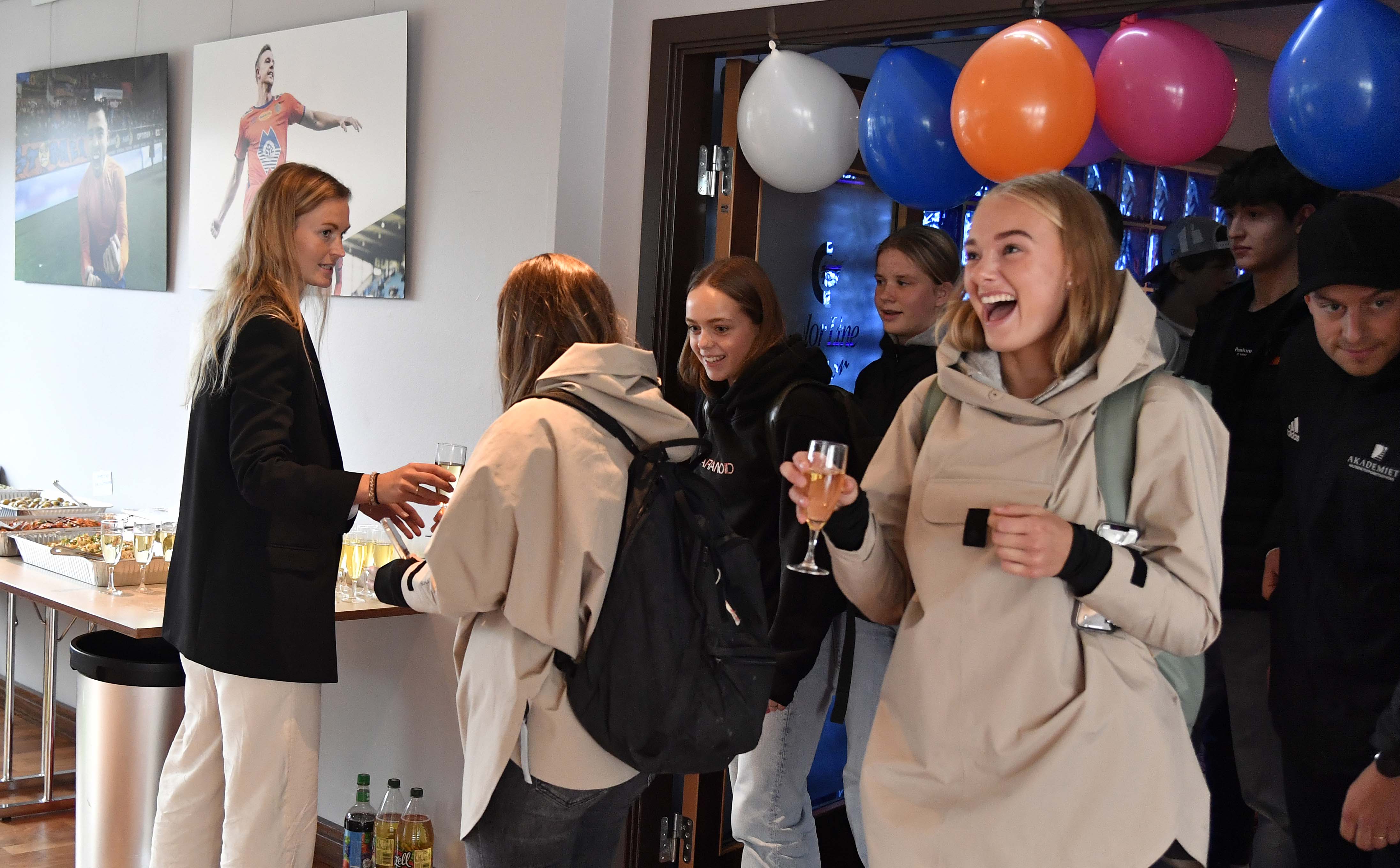 Lærer og AaFK Fortuna-spiller, Lise Janbu Eide (t.v) sto klar med velkomstbobler da elevene fikk se de nye skolelokalene på Color Line Stadion.