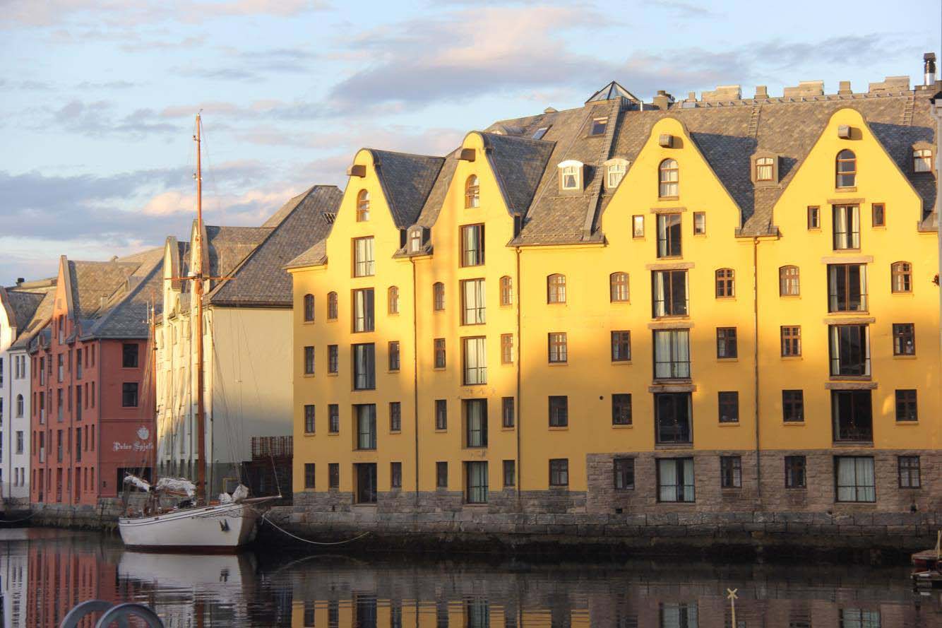 Solstrålene treffer Brosundet i Ålesund sentrum. Byen våkner til liv.