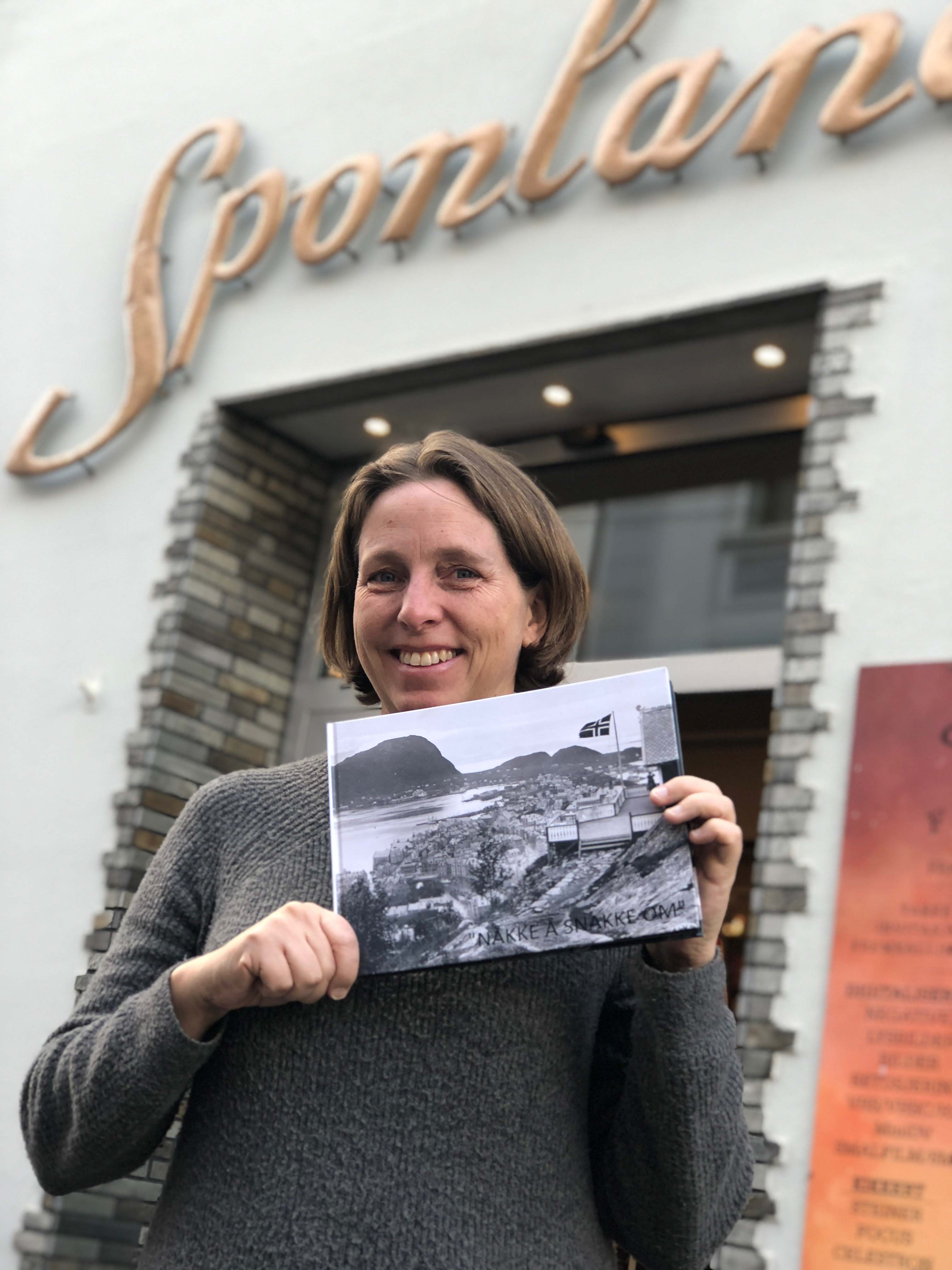 Marit Brunstad hos Sponland foto med boken som nå gleder beboere ved byens mange sykehjem.