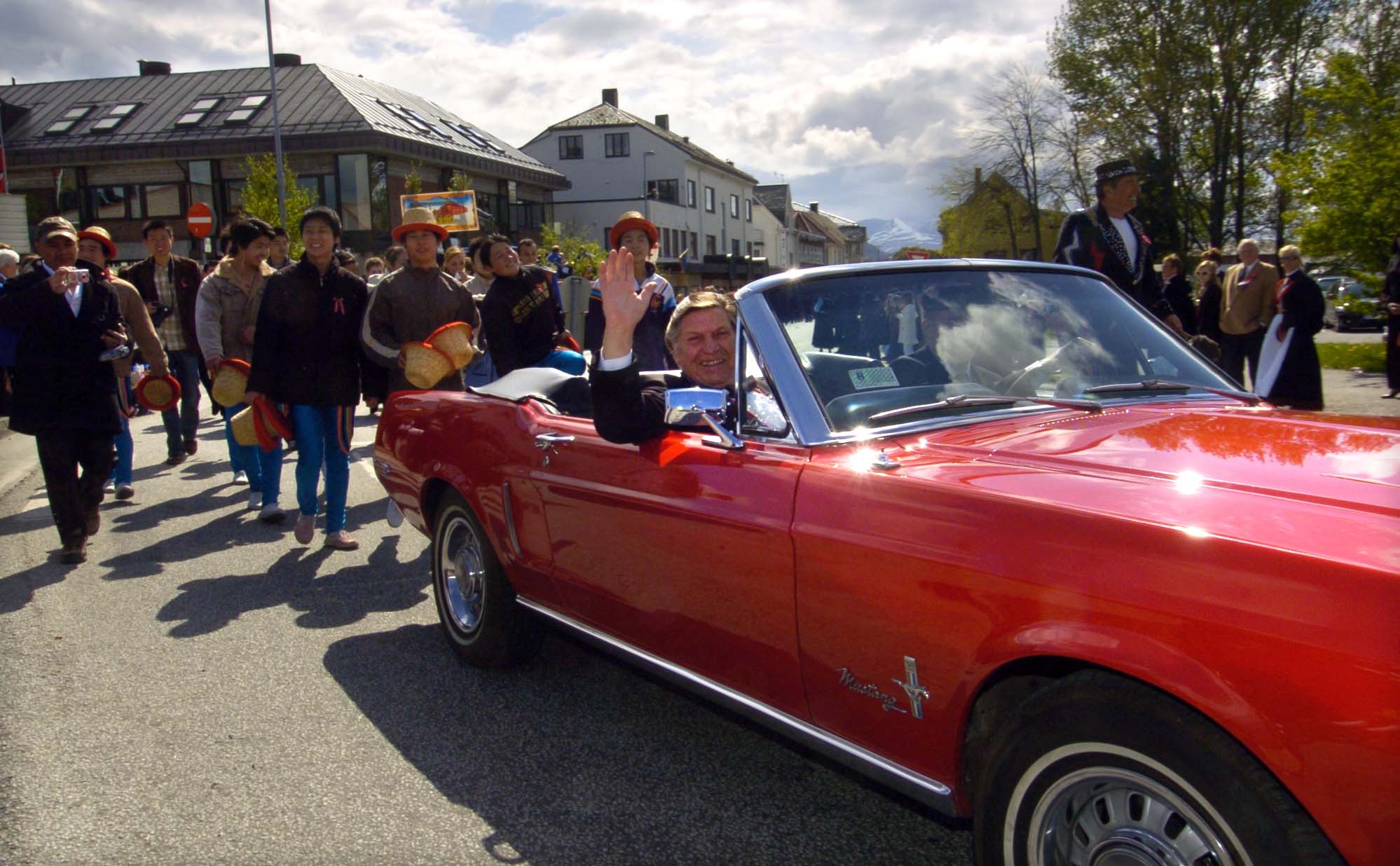 Med Arild Arnardo på plass i en rød Mustang. Bildet er tatt i Spjelkavika der Arnardo har gått i 17.mai toget siden cirkusplassen ble flyttet inn dit.