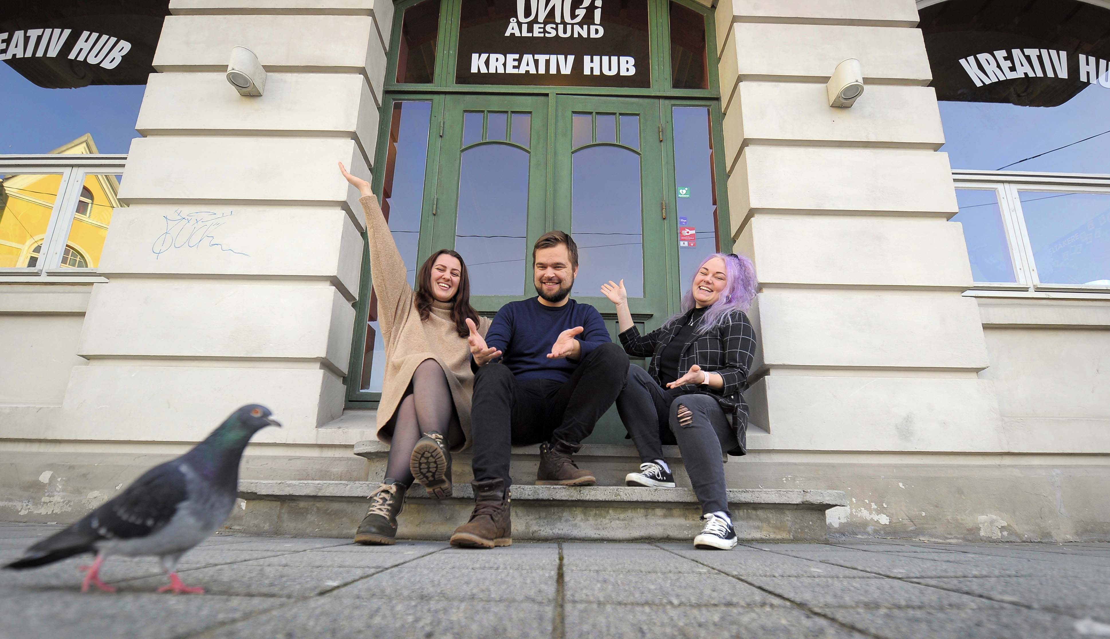 -Velkommen til Kreativ Hub i Arbeideren, sier Enya, Mathias og Karina. Ei kreativ og fotogen bydue ville gjerne være med på velkomstbildet.