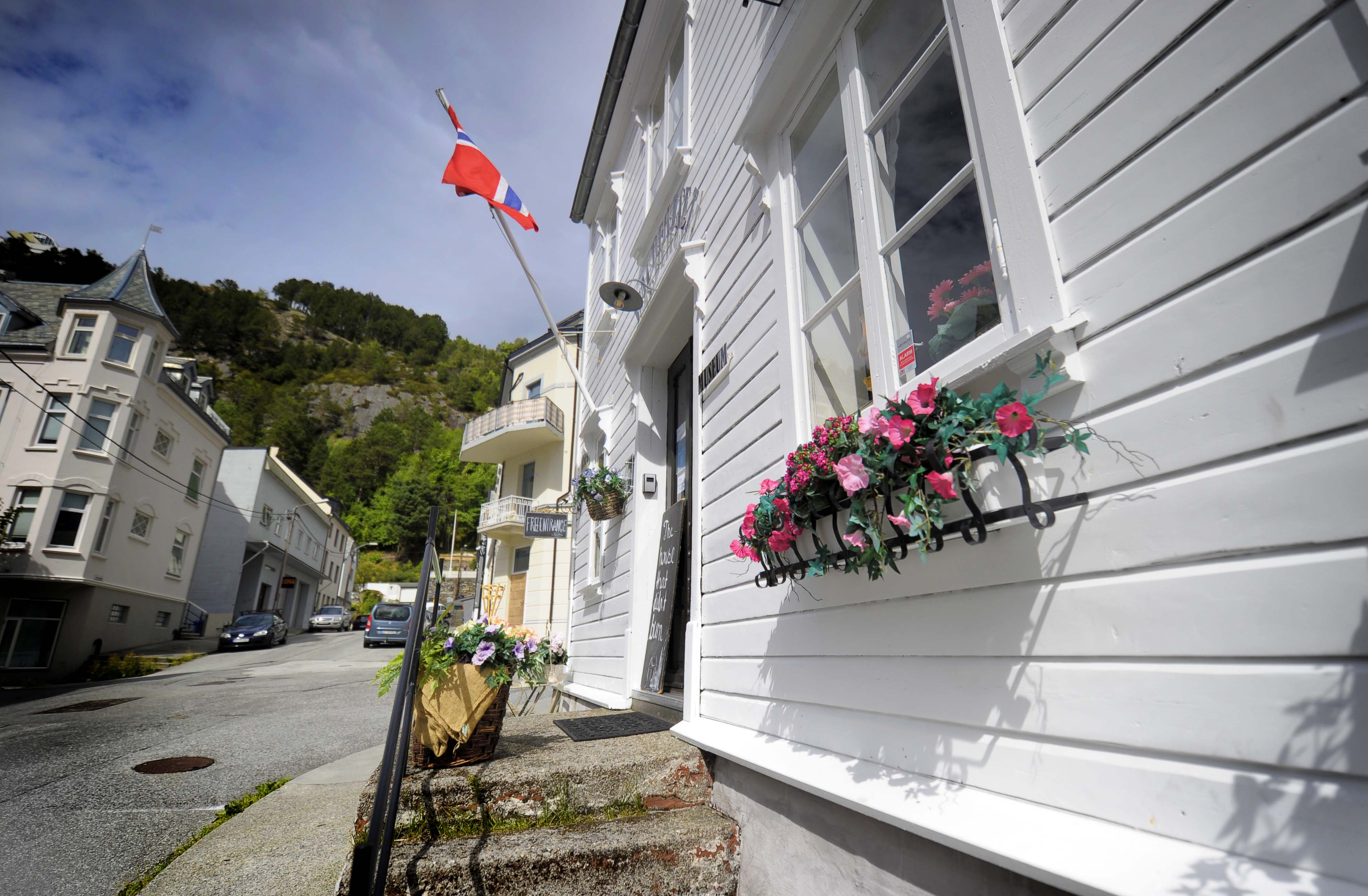 Blomster og flagg ønsker besøkende velkommen til Waldehuset.